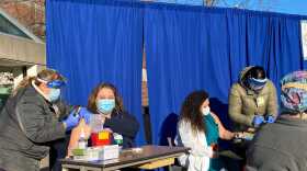 Healthcare workers get vaccinated outside at a clinic at Elliot Hospital. 