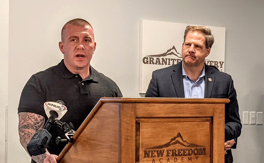 Eric Spofford at a lectern with Governor Chris Sununu behind