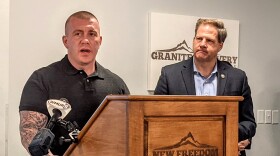 Eric Spofford at a lectern with Governor Chris Sununu behind