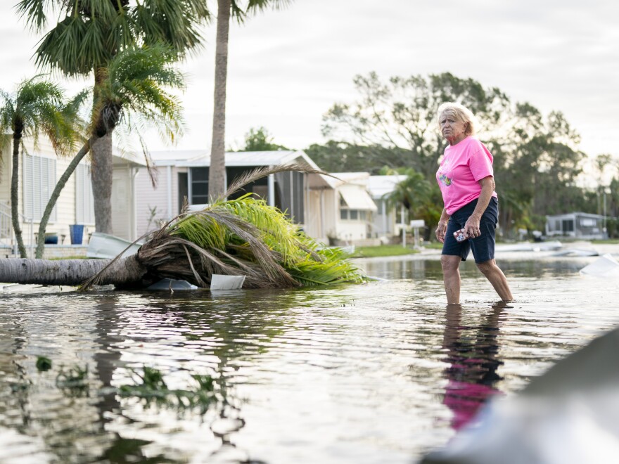 A woman walks along a flooded street in the aftermath of Hurricane Milton in Osprey, Florida. The hurricane made landfall as a Category 3 hurricane in the Siesta Key area.