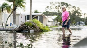 A woman walks along a flooded street in the aftermath of Hurricane Milton in Osprey, Florida. The hurricane made landfall as a Category 3 hurricane in the Siesta Key area.