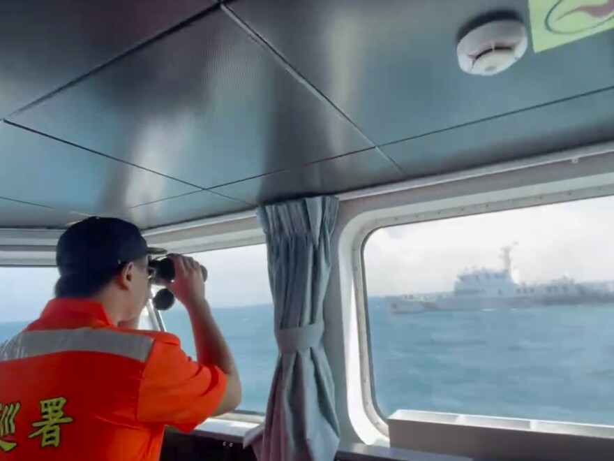 In this screen grab from video released by the Taiwan Coast Guard, a member of the Taiwan Coast Guard monitors a China Coast Guard boat as it passes near the coast of Matsu islands, Taiwan on Monday, Oct. 14, 2024.