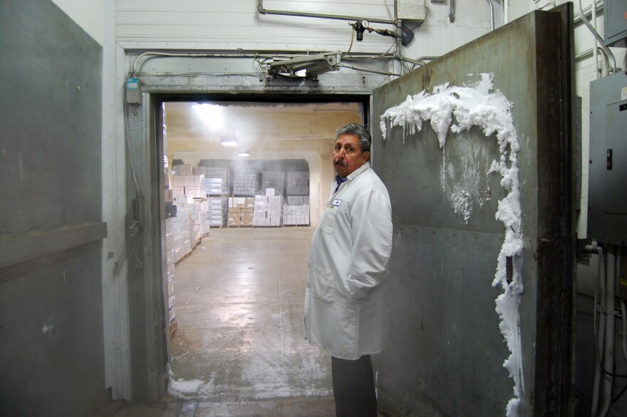 A worker at the Los Angeles Cold Storage Company stands at the entrance to a cold room