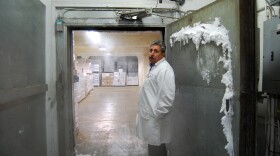 A worker at the Los Angeles Cold Storage Company stands at the entrance to a cold room