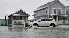 A driver heads south on Route 1A in Hampton Beach just before police closed that stretch of road due to coastal flooding Jan. 23, 2023.