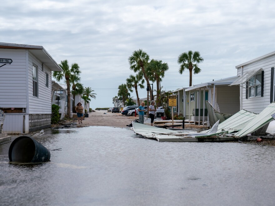 Residents of the community inspect damage around a trailer park on Longboat Key.