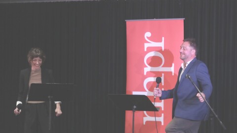 Co-Hosts Hannah McCarthy and Nick Capodice share a laugh onstage during the live taping at the Civics 101 Summit at Southern New Hampshire University on Sep. 28, 2024. Photo by Allegra Boverman