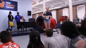 Raziel Vielmas, far left, and a group of kids watch a hands-on demonstration of an air cannon at the SEE Science Center in Manchester at a celebration of Hispanic Heritage Month on Friday, Oct. 4, 2024.