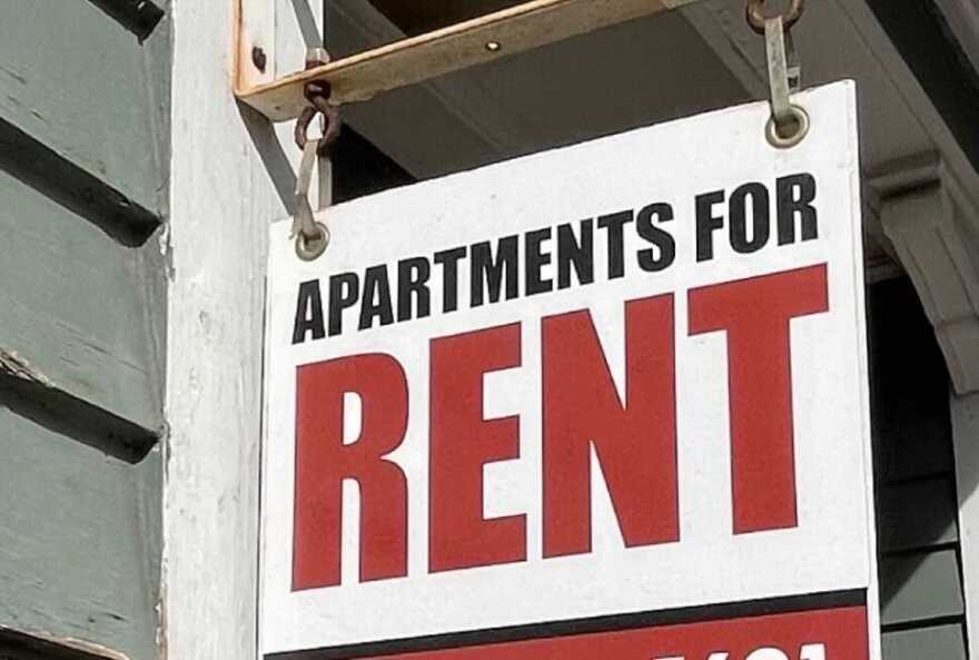 A sign saying "Apartments For Rent" hangs from a local building.