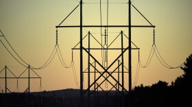 FILE - Power utility lines are seen, Wednesday, Oct. 6, 2021, in Pownal, Maine. A budget signed this week by Massachusetts Gov. Maura Healey clears the way for utilities to recover added costs caused by delays of a project to bring Canadian hydropower to the New England grid. The head of Central Maine Power’s corporate parent Avangrid previously said the cost of the $1 billion project grew to $1.5 billion because of delays and inflation during a prolonged court battle. (AP Photo/Robert F. Bukaty, File)