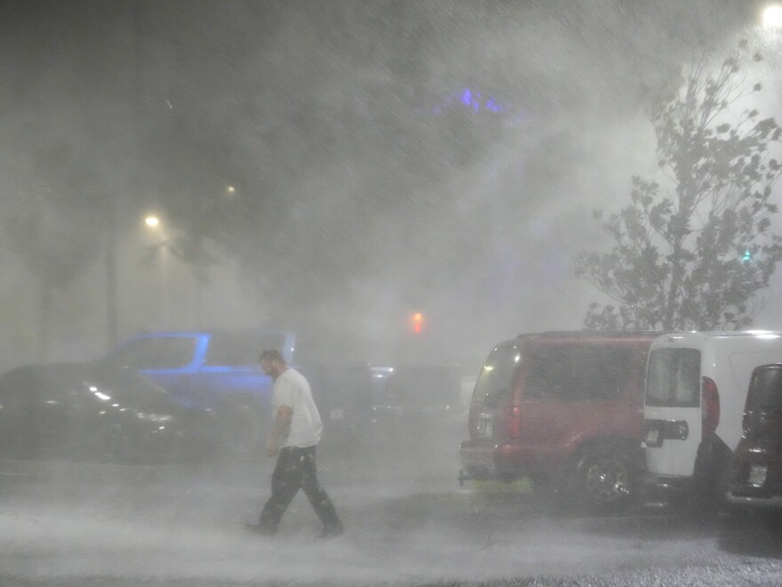 Max Watts, of Buford, Ga., walks in the parking lot to check on a trailer parked outside the hotel where he is riding out Hurricane Milton with coworkers in Tampa, Fla. Watts, who works for a towing company, was deployed with colleagues to Florida to aid in the aftermath of the storm.