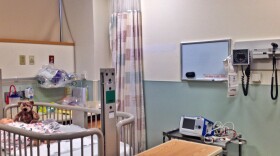  A hospital room with a bed for an infant and medical equipment 