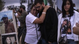 Two people embrace as relatives and supporters of Israelis killed in the Oct. 7, 2023 Hamas attack attend a ceremony at the Nova memorial near Kibbutz Reim in southern Israel on Oct. 7, 2024.