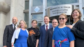 Parker Tirrell (third from left) and Iris Turmelle (second from right) gather outside the federal courthouse in Concord on Aug. 19, after a judge granted a temporary order allowing Tirrell to play for her school's soccer team. Tirrell and Turmelle are plaintiffs in a lawsuit challenging a new law that bans transgender girls from playing on girls' sports teams. They're joined here by their mothers and members of their legal team.