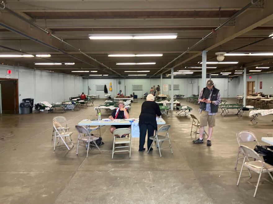 Folding chairs and tables are set up inside a large room