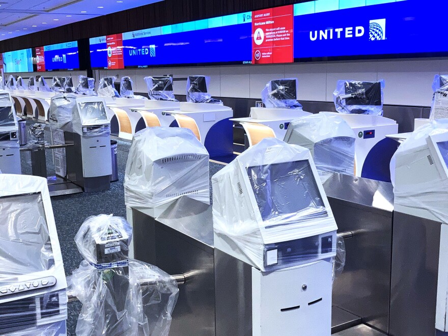 Flight check-in kiosks are seen covered in protective plastic at a deserted United Airlines check-in counter at Orlando International Airport ahead of the arrival of Hurricane Milton, in Orlando, Florida.