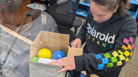 Jacqueline Zajac scans a bocce set to checkout. Renting 'a thing' uses the same process as a renting a book. Except people pick out an item displayed on the 'Library of Things' display card rack and take the card to the front desk where staff can grab items from a locked closet. Patrons then use their library card to check out items and return to the front desk when finished or loan period ends.