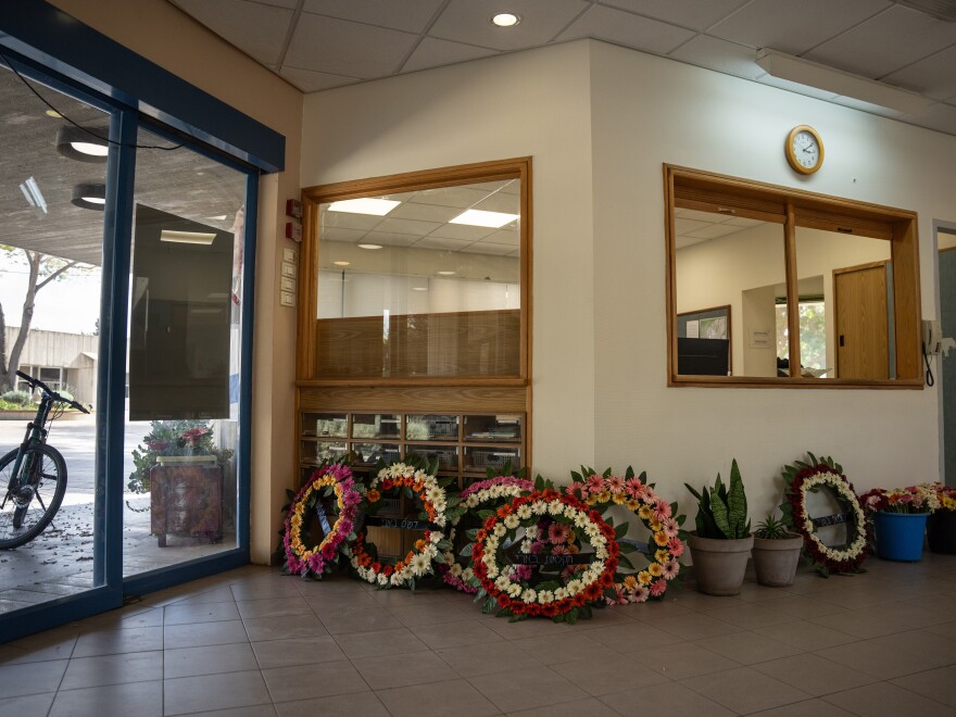 Funeral wreaths line a wall in the administrative office of Kibbutz Be'eri ahead of a reburial ceremony for a mother and son killed last Oct. 7. They had first been buried outside the kibbutz as it was not safe to gather there when the war started.