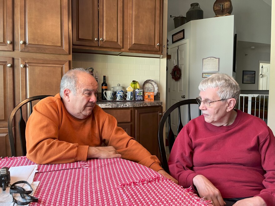 A couple sit at a kitchen table.