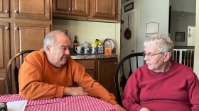 A couple sit at a kitchen table.