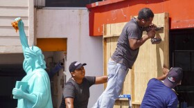 Workers place sheets of wood over windows and glass doors to protect them from the strong winds expected with the arrival of Hurricane Milton in the hotel zone of Cancun, Quintana Roo State, Mexico, on Monday. Hurricane Milton exploded in strength Monday to become a potentially catastrophic Category 5 storm bound for Florida, the second ferocious storm to hit the region in as many weeks.