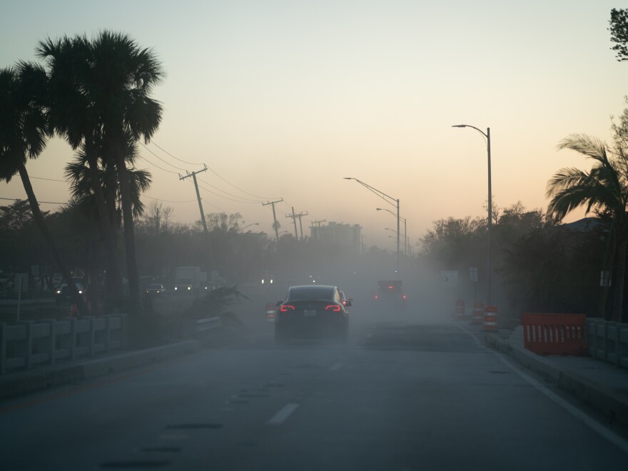 Sand and other debris are stirred up by cars and trucks as residents and workers return to Sarasota’s barrier islands after days after Hurricane Milton made landfall.