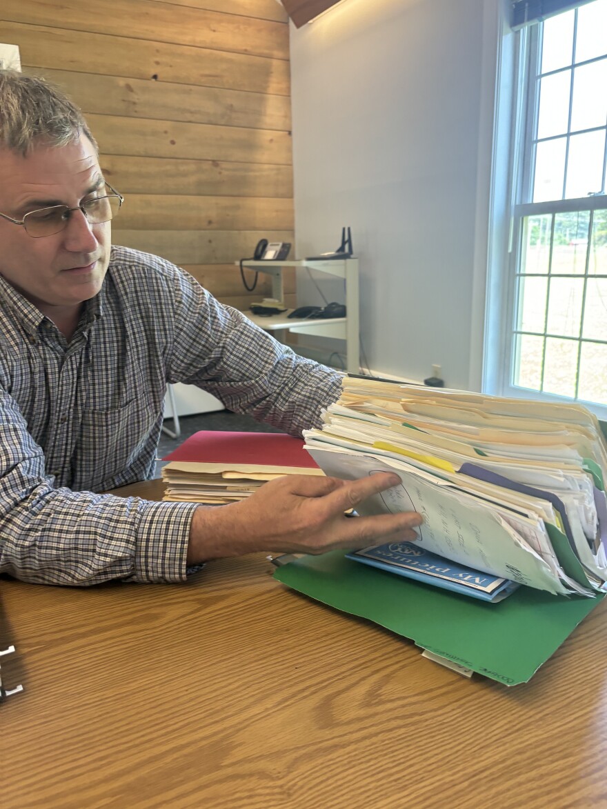 Patrick Tate sifts through one of the many folders containing New Hampshire mountain lion sighting reports.