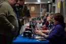 MJ McCobb, 43, second from right, helps already-registered voters get checked into vote at Milford High School on Tuesday, Jan. 23, 2023, in Milford, N.H. (Raquel C. Zaldívar/New England News Collaborative)