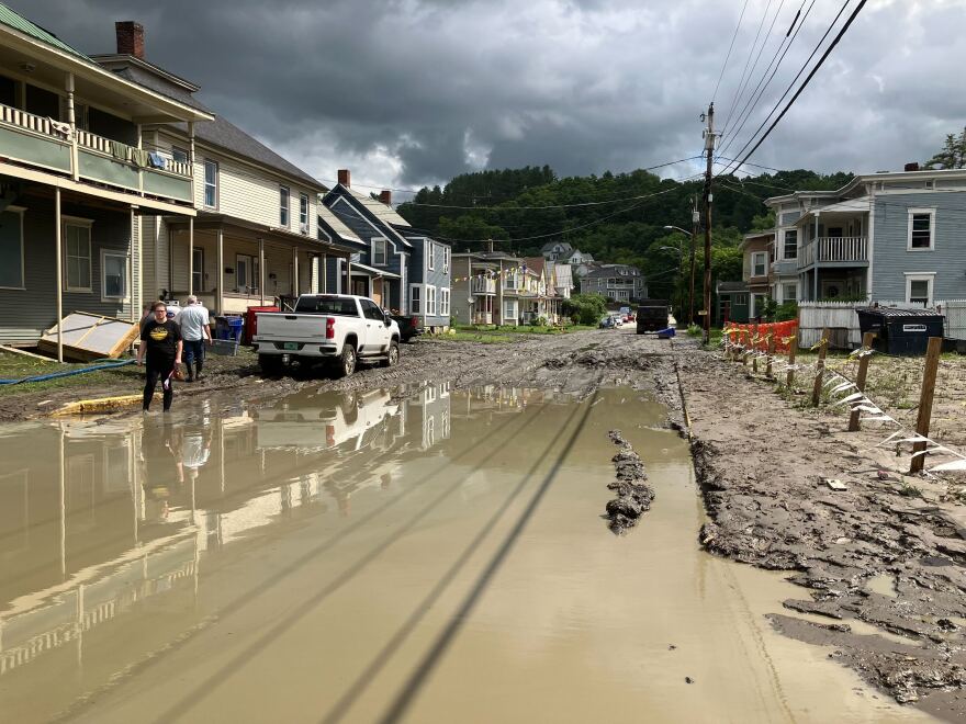 A residential street is covered in mud and water