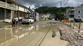 A residential street is covered in mud and water