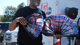 A vendor selling Harris-branded fans during a hot afternoon rally at Throwback Brewery.