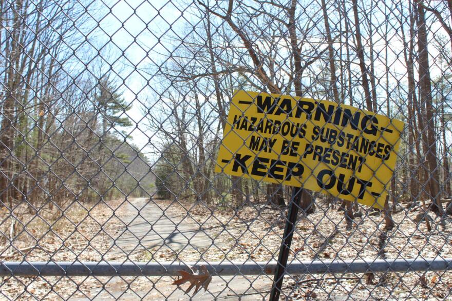 A warning sign on a fence outside the Coakley Landfill, a Superfund site in Greenland and North Hampton, NH. (NHPR file photo)