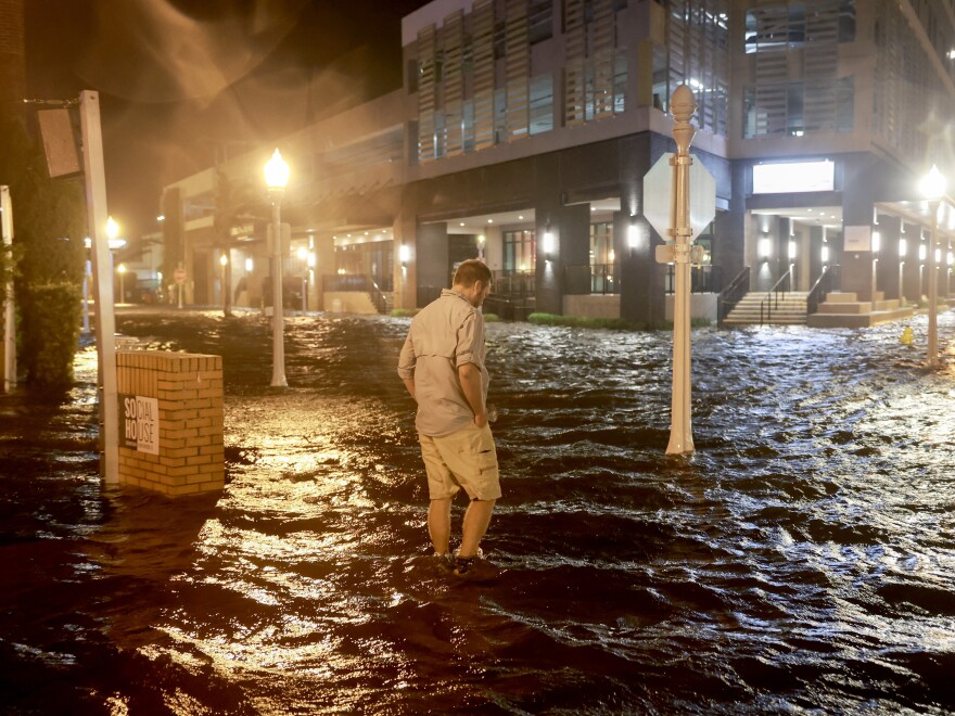 Brandon Marlow walks through surge waters flooding the street after Hurricane Milton came ashore in the Sarasota area in Fort Myers, Florida.