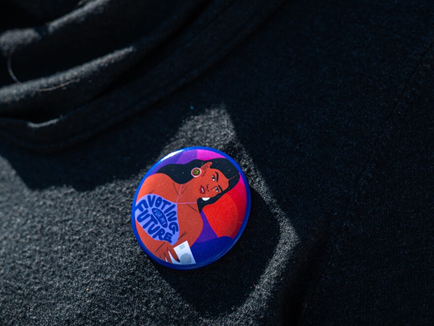 A woman wears a pin that reads "Voting for my Future" at the Gallup Flea Market in Gallup, N.M., on Oct. 12, 2024.