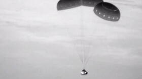  This image, taken from NASA video, shows the Boeing Starliner capsule coming down through the darkness over New Mexico. 