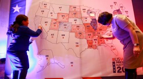 People color in a U.S. electoral map during a 2020 presidential election watch party at the U.S. embassy in Ulaanbaatar, Mongolia.