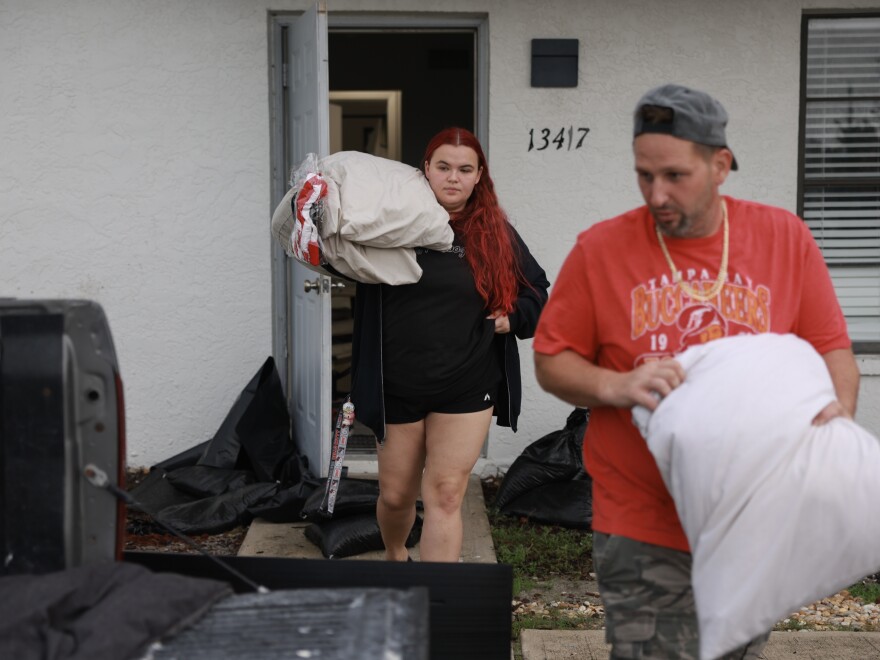 Payton Wyse (L) and Andrew Goncharsky pack what they can as they evacuate their apartment before Hurricane Milton's arrival in Fort Myers, Florida.