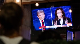 A person stops to watch a screen in Washington, D.C., displaying the presidential debate between Vice President Harris and former President Donald Trump in September.