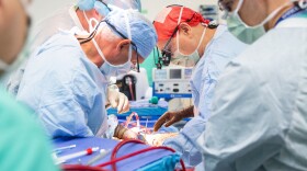 Dr. Marty Sellers, wearing a red scrub cap, and his team from Tennessee Donor Services perform a normothermic regional perfusion organ recovery at a hospital in eastern Tennessee.