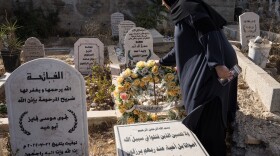 Hanan Khdour, 47, stands beside the grave of her son Mohammad Khdour in Biddu, West Bank, on Sept. 19, 2024. Mohammad, 17, and his cousin Malek Mansour, 16, also from Biddu, were driving in the hills not too far from their home in February 2024, when a man shot at their car from a distance as they were driving back.