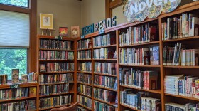 Bookshelves cover a wall. Above the shelves to the top left of the picture is a sign that says "teen reads."