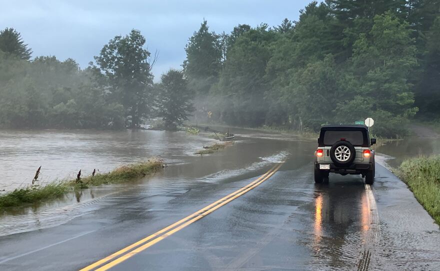 A vehicle is stopped before water on the roadway 