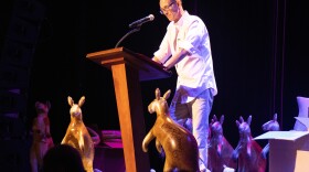 Chuck Palahniuk reads for the audience at The Music Hall, surrounded by inflatable kangaroos.