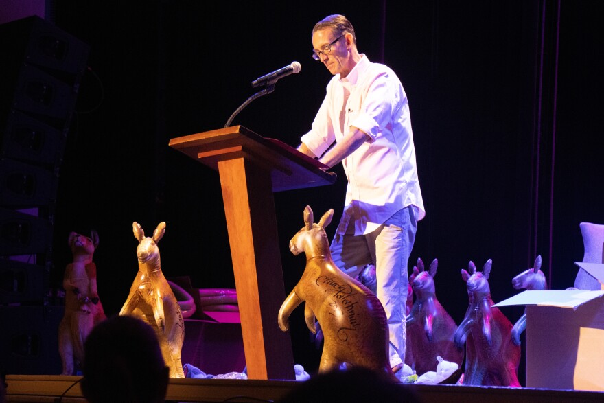 Chuck Palahniuk reads for the audience at The Music Hall, surrounded by inflatable kangaroos.