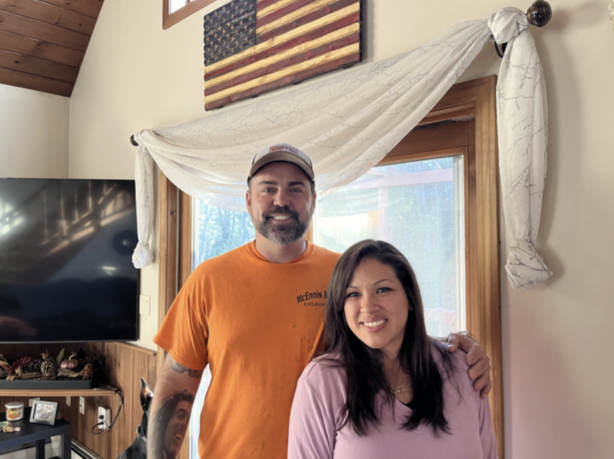 Mark and Pam McEnnis stand in their home, smiling.